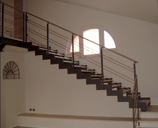 Scala a giorno con cosciali a scalino e ringhiera in acciaio.